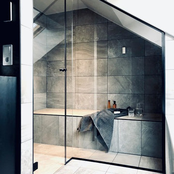 Badrum med walk-in shower, ångbad, snedtak och djupt takfönster.