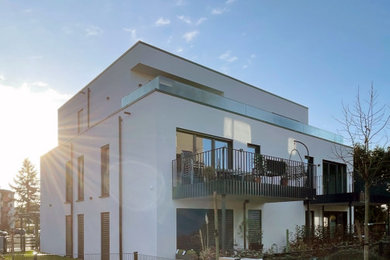 Dreistöckiges Modernes Haus mit Backsteinfassade, weißer Fassadenfarbe und Flachdach in Sonstige