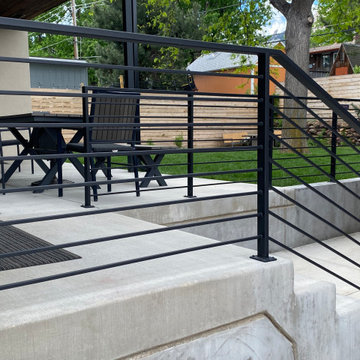 Mountain inspired minimalist boulder retaining walls and plantings.