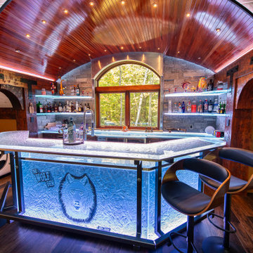 Glass private bar and glass stair treads inside a man cave in Michigan