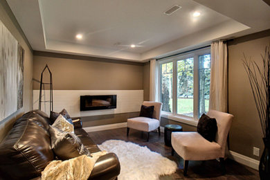 Example of a mid-sized trendy enclosed laminate floor and brown floor living room design in Other with brown walls, a standard fireplace and a stone fireplace