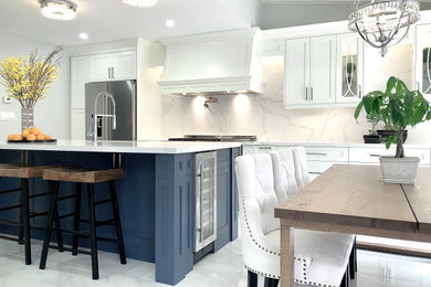 Eat-in kitchen - large transitional galley porcelain tile, white floor and vaulted ceiling eat-in kitchen idea in Toronto with a single-bowl sink, shaker cabinets, white cabinets, quartz countertops, white backsplash, quartz backsplash, stainless steel appliances, an island and white countertops