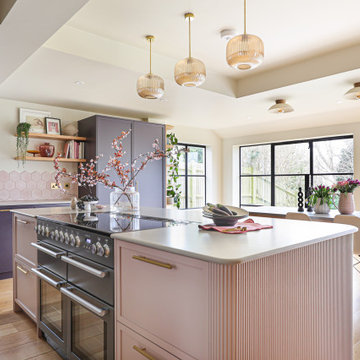 Pink kitchen island with fluted panelling and range oven