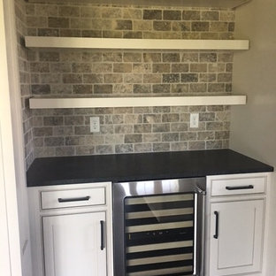コロンバスの小さいおしゃれなウェットバー (インセット扉のキャビネット、白いキャビネット、人工大理石カウンター、茶色いキッチンパネル、石タイルのキッチンパネル) の写真