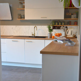 Mid-sized scandinavian kitchen pantry ideas - Mid-sized danish l-shaped slate floor and gray floor kitchen pantry photo in Nantes with an undermount sink, beaded inset cabinets, white cabinets, wood countertops, white backsplash, marble backsplash, paneled appliances, no island and beige countertops
