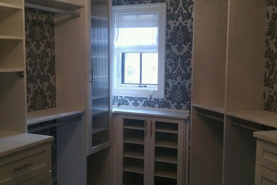 Large vintage gender neutral walk-in wardrobe in Other with shaker cabinets, white cabinets and dark hardwood flooring.