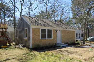 Small country blue one-story vinyl house exterior photo in Boston with a hip roof and a shingle roof