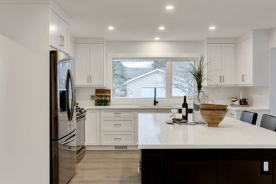 Inspiration for a mid-sized contemporary light wood floor eat-in kitchen remodel in Calgary with an undermount sink, shaker cabinets, white cabinets, quartz countertops, white backsplash, subway tile backsplash, stainless steel appliances, an island and white countertops