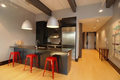 Large minimalist bamboo floor eat-in kitchen photo in New York with an undermount sink, shaker cabinets, black cabinets, granite countertops, gray backsplash, ceramic backsplash, stainless steel appliances and an island