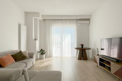Ejemplo de sala de estar cerrada actual de tamaño medio con paredes blancas, suelo de baldosas de porcelana y suelo beige
