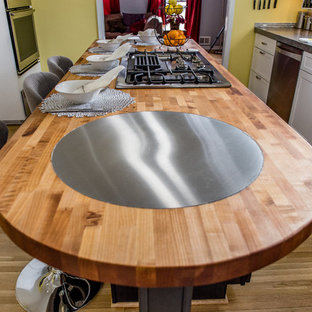 Aménagement d'une grande arrière-cuisine contemporaine en L avec un évier encastré, un placard à porte plane, des portes de placard blanches, un plan de travail en béton, une crédence métallisée, une crédence en carreau de verre, un électroménager en acier inoxydable, un sol en bois brun et un îlot central.