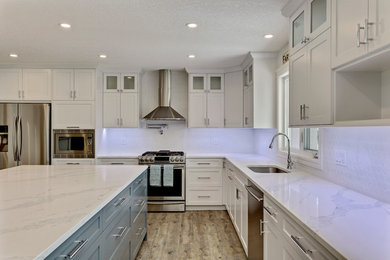 Example of a large country l-shaped vinyl floor and beige floor eat-in kitchen design in Calgary with an undermount sink, shaker cabinets, white cabinets, quartzite countertops, white backsplash, mosaic tile backsplash, stainless steel appliances, an island and white countertops