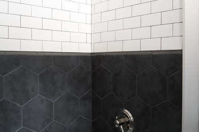 Small industrial bathroom in Portland Maine with a two-piece toilet, black and white tile, porcelain tile, white walls, porcelain floors and a pedestal sink.