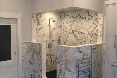 Large elegant master black and white tile and marble tile porcelain tile and brown floor bathroom photo in New York with flat-panel cabinets, white cabinets, a one-piece toilet, gray walls, an undermount sink, marble countertops and white countertops