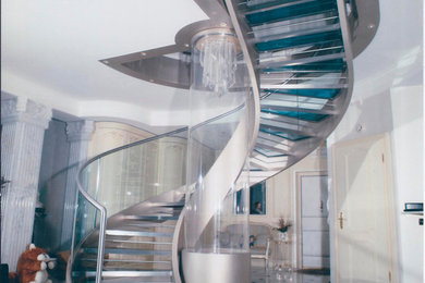Idée de décoration pour un escalier hélicoïdal design avec des marches en verre.
