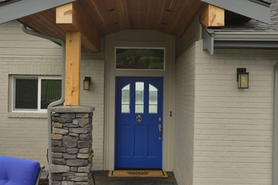 Elegant concrete floor entryway photo in Seattle with a blue front door