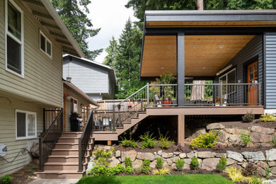 Inspiration for a large transitional backyard metal railing deck remodel in Seattle with a fire pit and a roof extension