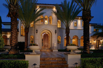 Photo of a large mediterranean two-storey beige exterior in Orlando with mixed siding.