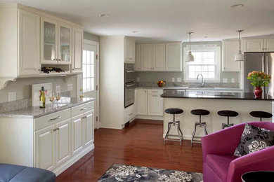 Transitional dark wood floor kitchen photo in Boston with an undermount sink, raised-panel cabinets, white cabinets, granite countertops, stainless steel appliances and an island
