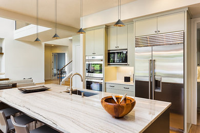 Foto de cocinas en U minimalista de tamaño medio abierto con suelo de madera en tonos medios, una isla y suelo beige