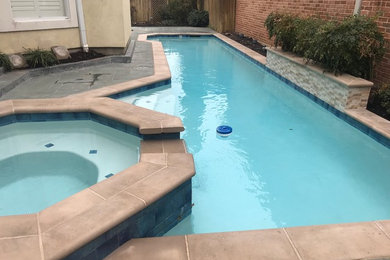 Photo of a mid-sized contemporary backyard rectangular lap pool in Dallas with a water feature and tile.