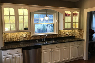 Example of a classic kitchen design in Indianapolis with granite countertops, beige backsplash and stone tile backsplash