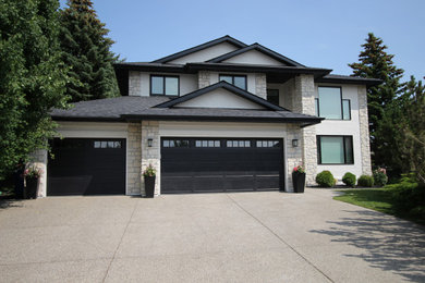 Inspiration for a large timeless white two-story stone house exterior remodel in Calgary