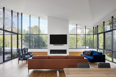 This is an example of a large open concept living room in Melbourne with a plaster fireplace surround and a wall-mounted tv.