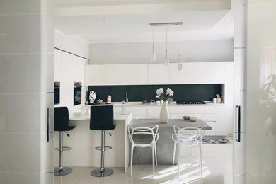 Ispirazione per una cucina moderna di medie dimensioni con lavello integrato, ante lisce, ante bianche, top in superficie solida, paraspruzzi nero, paraspruzzi in gres porcellanato, elettrodomestici in acciaio inossidabile, pavimento in gres porcellanato, penisola, pavimento bianco e top bianco