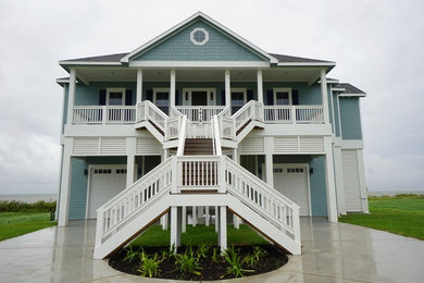 Design ideas for a large beach style two-storey blue exterior in Houston with concrete fiberboard siding and a hip roof.