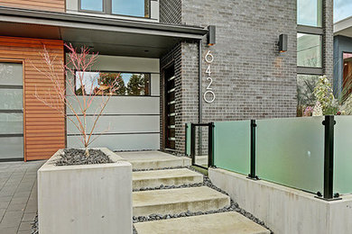 Mid-sized trendy brown two-story brick flat roof photo in Seattle