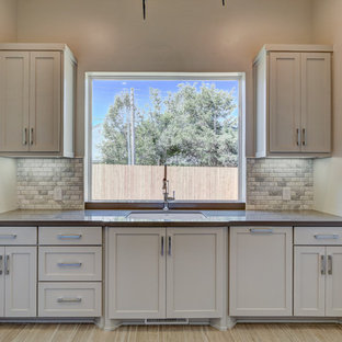 Design ideas for a medium sized contemporary u-shaped separated utility room in Oklahoma City with a submerged sink, recessed-panel cabinets, stainless steel cabinets, quartz worktops, grey walls, light hardwood flooring and a side by side washer and dryer.