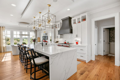 This is an example of a large country kitchen in DC Metro with shaker cabinets, medium wood cabinets, quartz benchtops, white splashback, engineered quartz splashback, panelled appliances, with island and white benchtop.