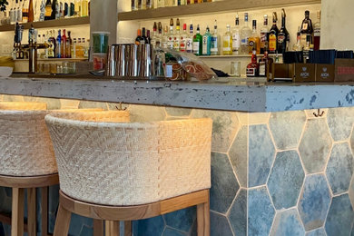 Example of an island style home bar design in Boston