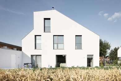 Mittelgroßes, Dreistöckiges Modernes Haus mit weißer Fassadenfarbe und Pultdach in Frankfurt am Main
