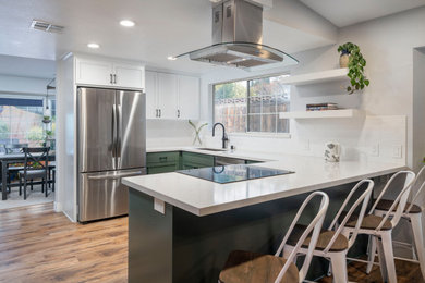 Mid-sized 1960s u-shaped vinyl floor and brown floor eat-in kitchen photo in Los Angeles with a single-bowl sink, shaker cabinets, green cabinets, quartz countertops, yellow backsplash, subway tile backsplash, stainless steel appliances, a peninsula and white countertops