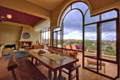Inspiration for a mid-sized mediterranean terra-cotta tile great room remodel in Minneapolis with beige walls, a standard fireplace and a stone fireplace