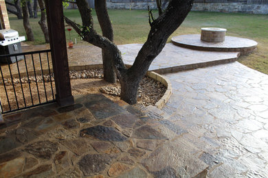 Large southwest backyard stone patio photo in Austin with a fire pit and no cover
