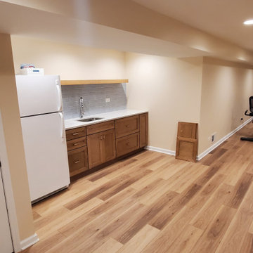 Fully remodeled 1970s finished basement with luxury vinyl plank flooring and can