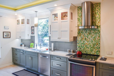 Open concept kitchen - mid-sized transitional galley light wood floor open concept kitchen idea in Jacksonville with a single-bowl sink, recessed-panel cabinets, gray cabinets, quartz countertops, green backsplash, mosaic tile backsplash, stainless steel appliances and no island