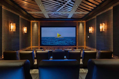 Inspiration for a large tropical enclosed home theatre in Hawaii with brown walls, carpet and a projector screen.