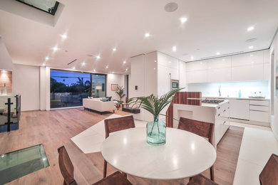 Mid-sized modern open plan dining in Los Angeles with white walls and light hardwood floors.