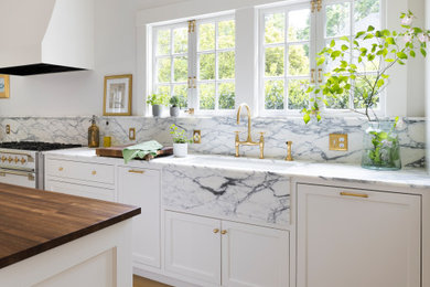 Inspiration for a large transitional u-shaped light wood floor and brown floor eat-in kitchen remodel in Portland with an undermount sink, recessed-panel cabinets, white cabinets, marble countertops, white backsplash, stone slab backsplash, white appliances, an island and white countertops