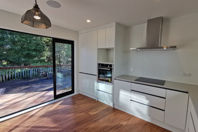 Foto de cocina minimalista de tamaño medio con puertas de armario blancas, encimera de cuarzo compacto y encimeras grises