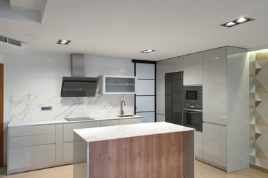 Diseño de cocina moderna de tamaño medio con armarios con paneles lisos, puertas de armario azules, encimera de cuarzo compacto, salpicadero blanco, puertas de cuarzo sintético, electrodomésticos de acero inoxidable, una isla, encimeras blancas y fregadero bajoencimera