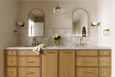 Example of a large tuscan master white tile and stone tile porcelain tile, multicolored floor and double-sink bathroom design in San Diego with shaker cabinets, light wood cabinets, a one-piece toilet, white walls, an integrated sink, quartz countertops and a built-in vanity