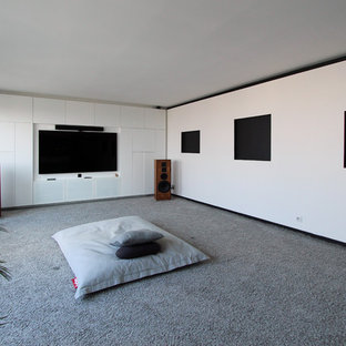 Example of a large trendy enclosed carpeted and gray floor home theater design in Paris with white walls and a wall-mounted tv