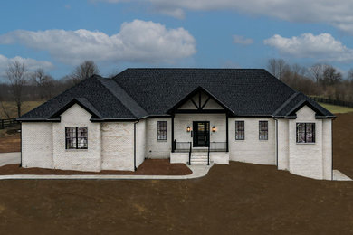 Modelo de fachada de casa blanca y negra campestre grande de dos plantas con revestimiento de ladrillo, tejado a cuatro aguas y tejado de teja de madera