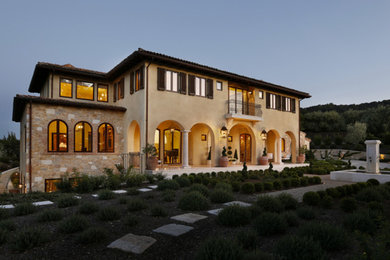 Inspiration for a large mediterranean limestone floor entryway remodel in San Francisco with beige walls and a medium wood front door