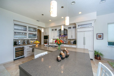 Example of a mid-sized transitional travertine floor and brown floor eat-in kitchen design in Tampa with an undermount sink, recessed-panel cabinets, white cabinets, quartz countertops, multicolored backsplash and glass tile backsplash